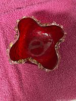 Top view showing red body and clear ruffled rim with gold flecks