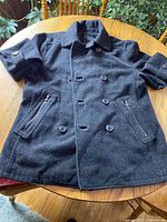 Full view of charcoal double-breasted Sears Heritage coat laid flat