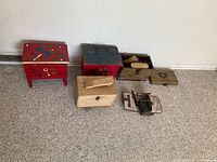 Five shoe shine kit containers on carpet