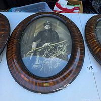 Three oval wood frames with tiger-stripe veneer; two contain antique portraits, one empty