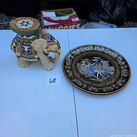 Elephant figurine stand and decorative plate on table
