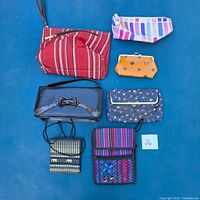 All seven bags and pouches laid out on blue background