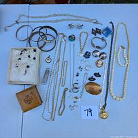 Full layout of jewelry lot showing chains, bangles, necklaces, earrings, rings, brooch and wooden box