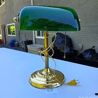 Front view showing green glass shade, brass base, cord, pull chain