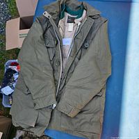 Full view of olive green down jacket laid flat