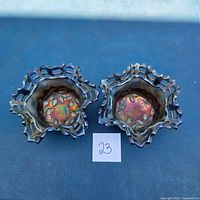 Both Fenton carnival glass bowls top view showing iridescence and blackberry pattern