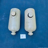 Pair of beige stoneware hot water bottles, top view showing stoppers