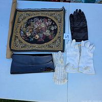 Overview of tapestry, three pairs gloves, black patent clutch