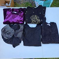 Five folded sweaters on table showing overall lot