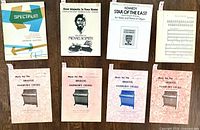 All eight music books laid out, front covers visible