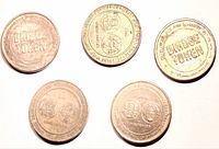 Group shot of five brass commuter bridge tokens, both faces visible