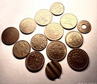 Group view showing all fourteen brass tokens with varying designs