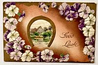 Front of embossed postcard with flowers, horseshoe, cottage view, Good Luck text