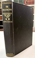 Front and spine view showing black cloth binding, gilt spine text and ornament, blind-stamped front board monogram