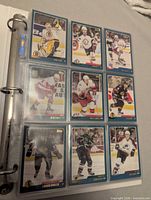 Nine cards in binder page showing various players