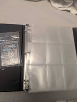 Binder open showing nine-pocket pages and sealed Ultra PRO screw-down holder