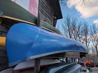 side view of blue fiberglass canoe on storage rack