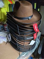 Stack showing brown felt cowboy hats with tags