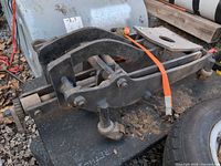 Side view of transmission jack dolly showing frame, casters, mounting hardware, orange strap