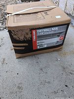 Full view of boxed drywall nails with product label visible