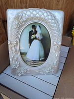 Front view of one ornate ivory pearl resin frame with sample wedding photo