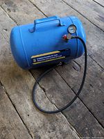 Full view of blue Power Fist 5-gallon air tank with hose and handle