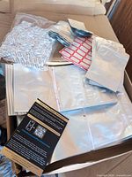 Open box showing stacks of Mylar bags, oxygen absorber packets, and labels