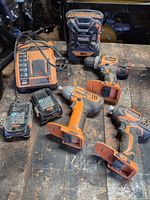 Group view of charger, two batteries, drill/driver, two impact drivers and jobsite radio