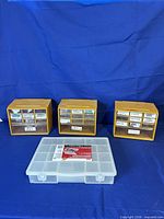Three yellow drawer cabinets and one clear multi-compartment box displayed