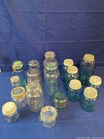 Group shot of all aqua and clear Ball jars with lids to show quantity and variety