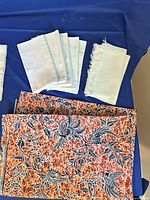 Pale blue napkins, raw-edge fabric pieces, coral floral tea cloths