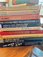 Stack of 10 paperbacks showing Faulkner and Greene titles