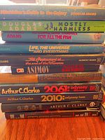 Stack of 11 science-fiction titles by Adams, Asimov and Clarke