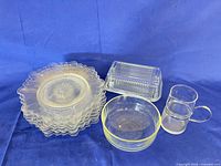 stack of eight scalloped dessert plates, butter dish with lid, bowl, and creamer grouped