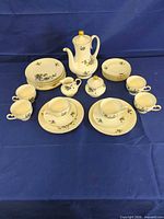 Full view of complete 21-piece tea set with cups, saucers, plates, teapot, sugar bowl, creamer