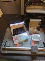 Paper cutter with assorted small supplies and waste basket visible