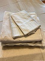 Beige striped sheet set folded showing pillowcase and sheets