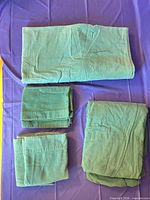 Folded green sheet set: fitted, flat, pillowcases, shams