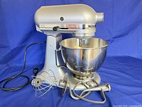 KitchenAid stand mixer with bowl and three attachments displayed