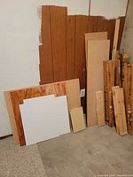 Group of sheet goods and dimensional lumber leaning against wall