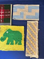 Four textile panels laid out on blue background showing designs and condition