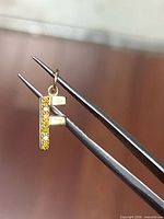 Front view of gold letter F pendant with yellow diamonds