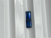 Two baguette-cut sapphires stacked vertically showing color and clarity