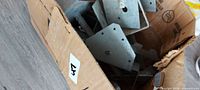 overview of cardboard box filled with galvanized steel brackets