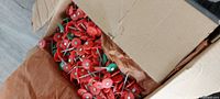 Open box showing large quantity of red plastic cap nails