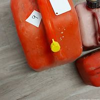 close-up of large orange gas can showing condition, cap and spout