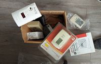 Top view of box with various thermostats and alarm parts