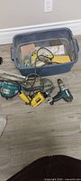 Overview of tote with Makita jigsaw, DeWalt drill, cordless drill body and drywall tools