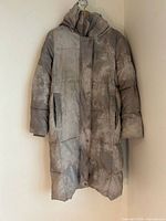 Front view of grey Andrew Marc long puffer coat showing length, pockets and closure.
