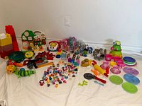 Wide view of entire assortment showing Shopkins cluster, kitchenware, tools, figurines, blocks and playsets